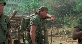 Movie still from “Platoon” (1986), directed by Oliver Stone – A man with a backpack standing in the woods; Medium shot, Low angle