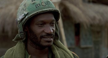 Movie still from “Platoon” (1986), directed by Oliver Stone – A person wearing a helmet; Close Up shot, Low angle