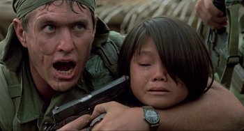 Movie still from “Platoon” (1986), directed by Oliver Stone – A man and a woman are holding a gun; Close Up shot, Low angle