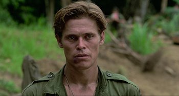 Movie still from “Platoon” (1986), directed by Oliver Stone – A person wearing a green shirt; Close Up shot, Low angle