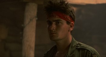 Movie still from “Platoon” (1986), directed by Oliver Stone – A man with a red bandanna on his head; Close Up shot, Low angle