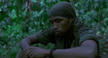 Movie still from “Platoon” (1986), directed by Oliver Stone – A man with a bandanna is sitting in the woods; Close Up shot, Low angle