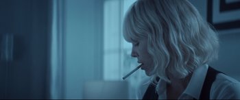 Movie still from “Atomic Blonde” (2017), directed by David Leitch – A woman is holding a cigarette in her mouth; Close Up shot, Low angle