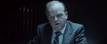 Movie still from “Atomic Blonde” (2017), directed by David Leitch – A man in a suit and tie looking at the camera; Close Up shot, Over the shoulder angle