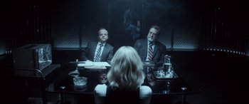 Movie still from “Atomic Blonde” (2017), directed by David Leitch – A man and a woman sitting in front of each other in front of a mirror; Medium shot, Over the shoulder angle
