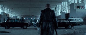 A man walking in a parking lot with a bag