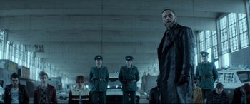 Movie still from “Atomic Blonde” (2017), directed by David Leitch – A group of men standing next to each other in front of a car; Medium shot, Low angle