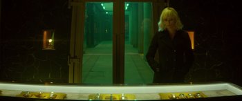 Movie still from “Atomic Blonde” (2017), directed by David Leitch – A woman standing in front of a mirror in a room; Medium shot, Low angle