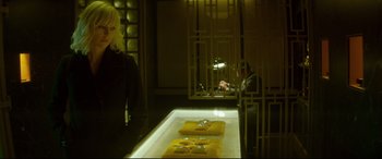 A woman standing in front of a table with a glass on it