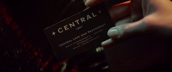 Movie still from “Atomic Blonde” (2017), directed by David Leitch – A person holding a business card in their hand; Extreme Close Up shot, Overhead angle