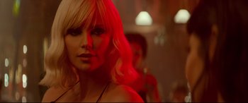 Movie still from “Atomic Blonde” (2017), directed by David Leitch – A woman with blonde hair and a red light; Close Up shot, Over the shoulder angle