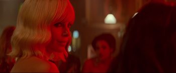 Movie still from “Atomic Blonde” (2017), directed by David Leitch – A woman with blonde hair and a red wig; Close Up shot, Over the shoulder angle