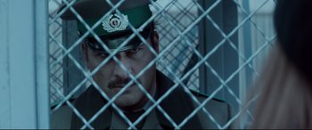 Movie still from “Atomic Blonde” (2017), directed by David Leitch – A person behind a chain link fence; Close Up shot, Low angle