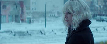 Movie still from “Atomic Blonde” (2017), directed by David Leitch – A woman with blonde hair is looking out of a window; Close Up shot, Over the shoulder angle