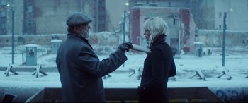 Movie still from “Atomic Blonde” (2017), directed by David Leitch – A man and a woman standing next to each other outside; Medium shot, Over the shoulder angle