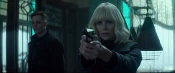 Movie still from “Atomic Blonde” (2017), directed by David Leitch – Charlize theron in atomic blonde holding a gun; Close Up shot, Over the shoulder angle