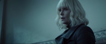 Movie still from “Atomic Blonde” (2017), directed by David Leitch – A woman with blonde hair and blue eyes looking to her left; Close Up shot, Low angle