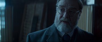 Movie still from “Atomic Blonde” (2017), directed by David Leitch – An old man with a beard wearing a suit and tie; Close Up shot, Over the shoulder angle