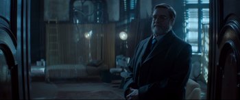 Movie still from “Atomic Blonde” (2017), directed by David Leitch – A man in a suit and tie standing in a room; Medium shot, Over the shoulder angle