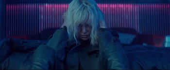 Movie still from “Atomic Blonde” (2017), directed by David Leitch – A woman with her hands on her head; Close Up shot, Low angle