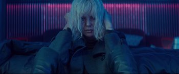 Movie still from “Atomic Blonde” (2017), directed by David Leitch – A woman with white hair holding her hands behind her head; Close Up shot, Low angle