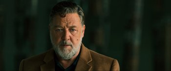 Movie still from “Poker Face” (2022), directed by Russell Crowe – An older man wearing a brown jacket looking at the camera; Close Up shot, Low angle