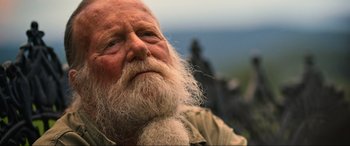 Movie still from “Poker Face” (2022), directed by Russell Crowe – An old man with a long white beard; Close Up shot, Over the shoulder angle