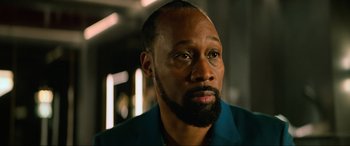 Movie still from “Poker Face” (2022), directed by Russell Crowe – A person with a beard looking at the camera; Close Up shot, Low angle