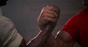 Movie still from “Predator” (1987), directed by John McTiernan – View of a man's arm and fist; Close Up shot, Overhead angle