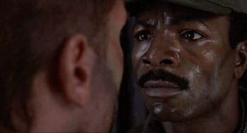 Movie still from “Predator” (1987), directed by John McTiernan – A man looking at himself in the mirror; Close Up shot, Over the shoulder angle