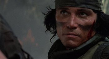 Movie still from “Predator” (1987), directed by John McTiernan – A man's face with a bandage on his head; Close Up shot, Low angle