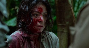 Movie still from “Predator” (1987), directed by John McTiernan – A woman with blood all over her face; Close Up shot, High angle
