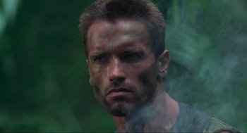 Movie still from “Predator” (1987), directed by John McTiernan – A person wearing a shirt; Close Up shot, Low angle