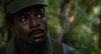 Movie still from “Predator” (1987), directed by John McTiernan – A person wearing a hat; Close Up shot, Low angle