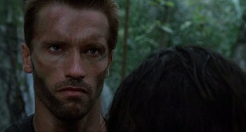 Movie still from “Predator” (1987), directed by John McTiernan – A person with a face tattoo; Close Up shot, Over the shoulder angle