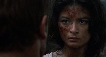 Movie still from “Predator” (1987), directed by John McTiernan – A young woman looking into a mirror with blood all over her face; Close Up shot, Over the shoulder angle