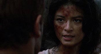 Movie still from “Predator” (1987), directed by John McTiernan – A person looking at the camera; Close Up shot, Over the shoulder angle