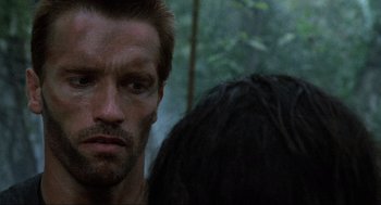 Movie still from “Predator” (1987), directed by John McTiernan – A man's face and a woman's face; Close Up shot, Over the shoulder angle
