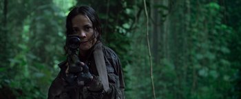 Movie still from “Predators” (2010), directed by Nimród Antal – A woman holding a gun in a forest; Close Up shot, Low angle