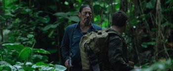 Movie still from “Predators” (2010), directed by Nimród Antal – A man with a gun in his hand and another man with a backpack in the woods; Medium shot, Over the shoulder angle