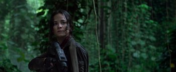 Movie still from “Predators” (2010), directed by Nimród Antal – A woman in the woods holding a remote control; Close Up shot, Low angle