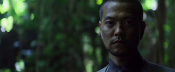 Movie still from “Predators” (2010), directed by Nimród Antal – A person wearing a suit and tie; Close Up shot, Low angle