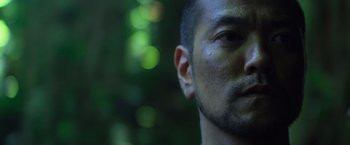 Movie still from “Predators” (2010), directed by Nimród Antal – A man's face in front of a blurry background; Extreme Close Up shot, Low angle
