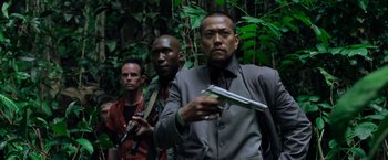 Movie still from “Predators” (2010), directed by Nimród Antal – A group of men standing next to each other in the woods; Medium shot, Low angle