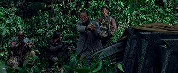 Movie still from “Predators” (2010), directed by Nimród Antal – A group of men standing next to each other in the woods; Medium shot, Over the shoulder angle