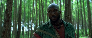 Movie still from “Predators” (2010), directed by Nimród Antal – A man with a beard is standing in the woods; Close Up shot, Low angle