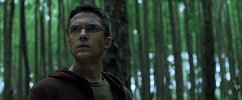 Movie still from “Predators” (2010), directed by Nimród Antal – A person wearing glasses in the woods; Close Up shot, Low angle