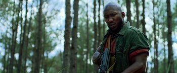 Movie still from “Predators” (2010), directed by Nimród Antal – A man holding a gun in a forest; Close Up shot, Low angle