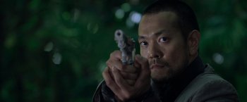 Movie still from “Predators” (2010), directed by Nimród Antal – A man is holding a gun in his hand; Close Up shot, Low angle