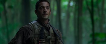 Movie still from “Predators” (2010), directed by Nimród Antal – A person in a forest; Close Up shot, Low angle